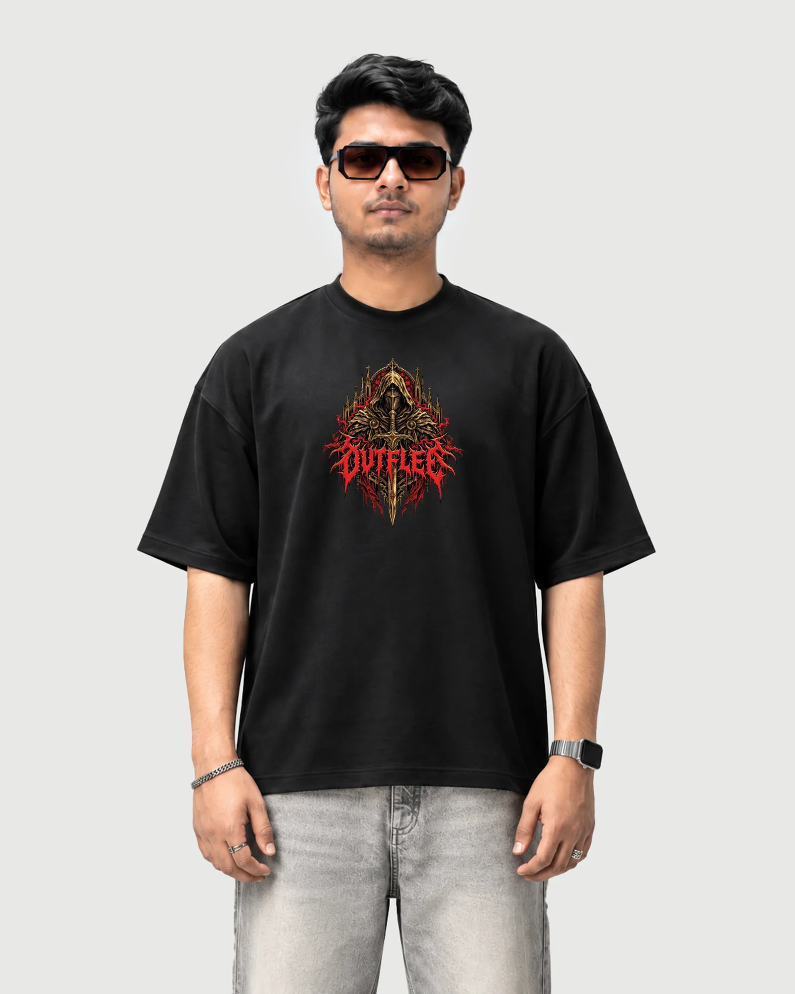 Model wearing the black Outflee Crimson Warden drop shoulder T-shirt, front view showing the gold hooded warrior, sword and red Outflee chest artwork.
