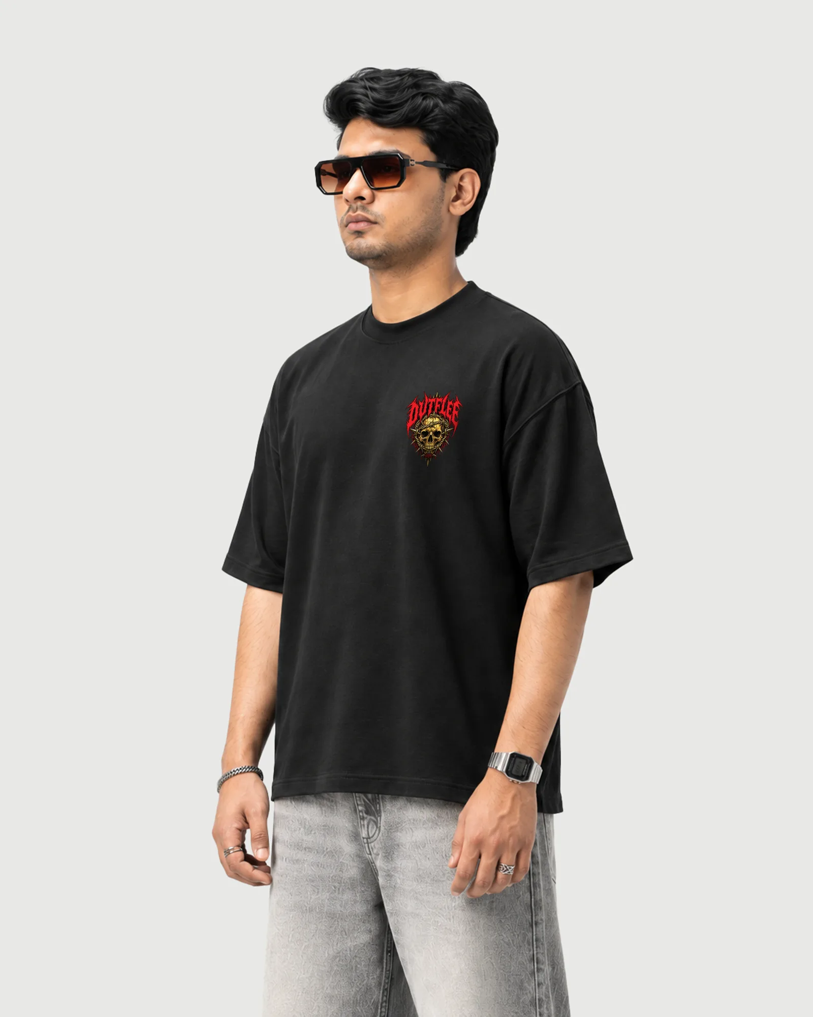 Three-quarter view of a model wearing the black Outflee Thornbound Skull T-shirt, showing the relaxed fit, dropped shoulders and chest graphic.