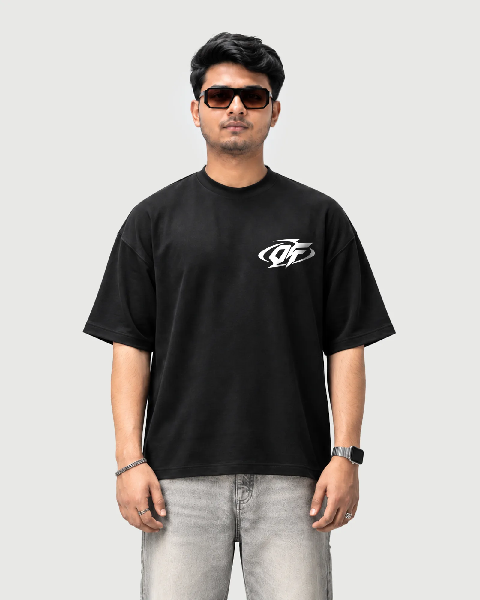 Model wearing the black Outflee Small City Big Dreams drop shoulder T-shirt, front view with a small white chest logo.