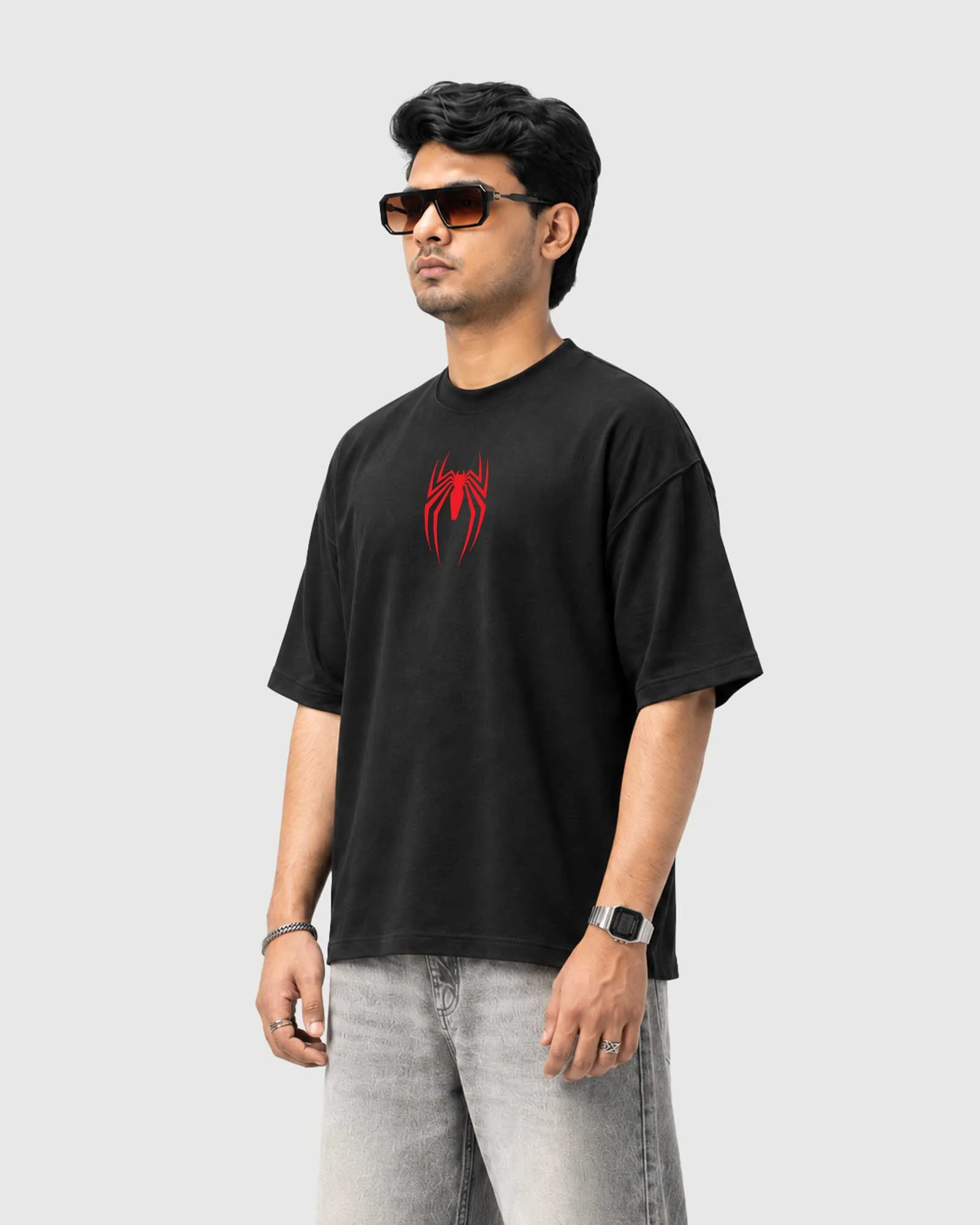 Three-quarter view of a model wearing the black Outflee Creeping Silence drop shoulder T-shirt, showing the relaxed fit and red spider front print.