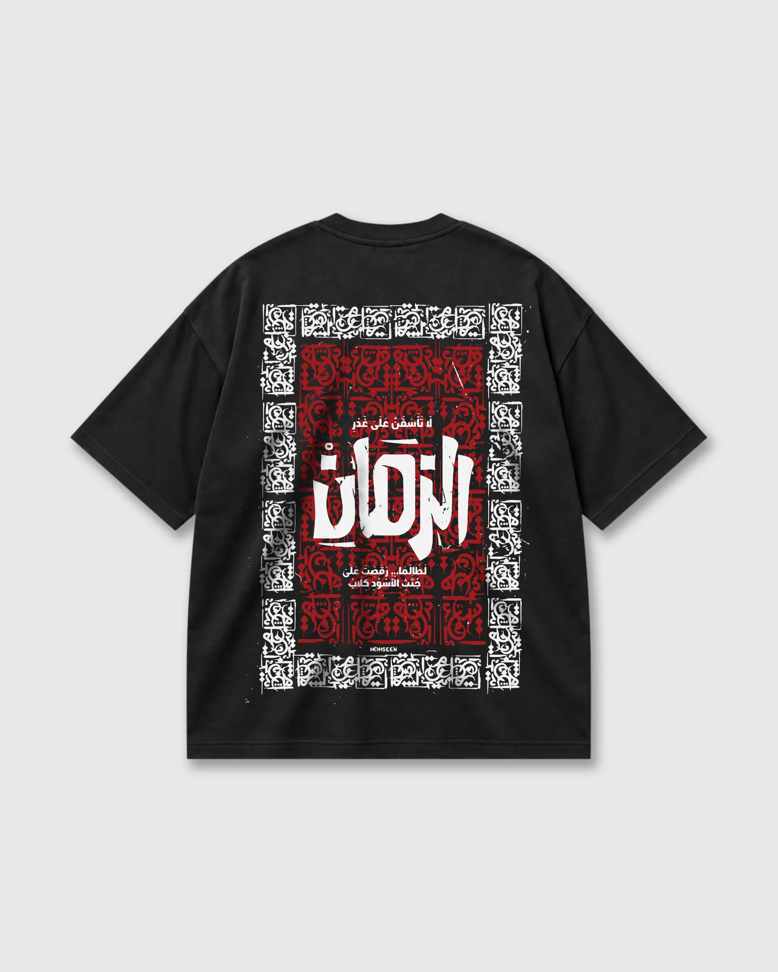 Back of a black Outflee Arabic Calligraphy drop shoulder T-shirt with large red, white and black Arabic calligraphy artwork in an ornamental frame.