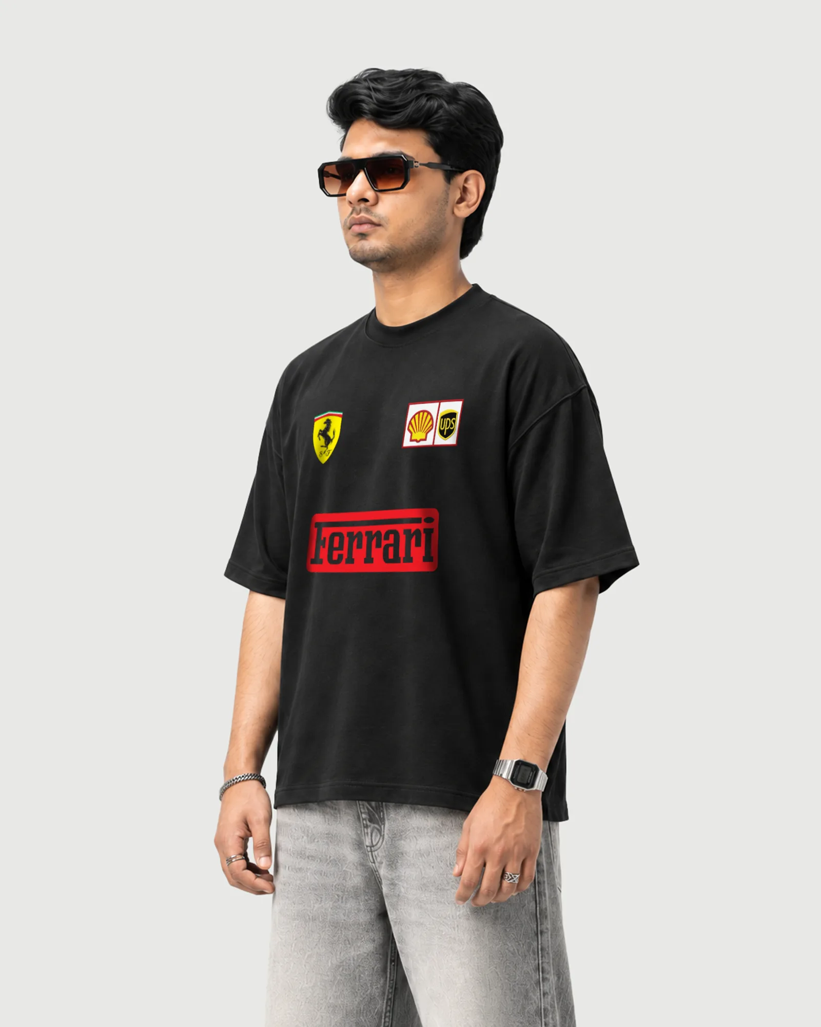 hree-quarter view of a model wearing the black Outflee Ferrari Formula 1 graphic drop shoulder T-shirt, showing the relaxed fit and motorsport-inspired front print.