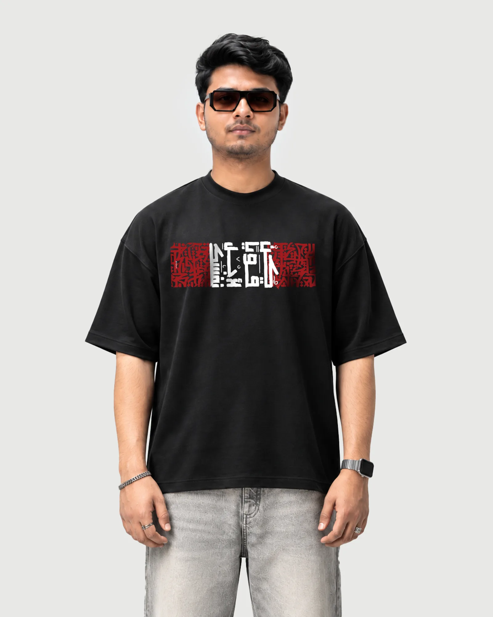 Model wearing the black Outflee Arabic Calligraphy drop shoulder T-shirt, front view showing the red and white calligraphy chest print.