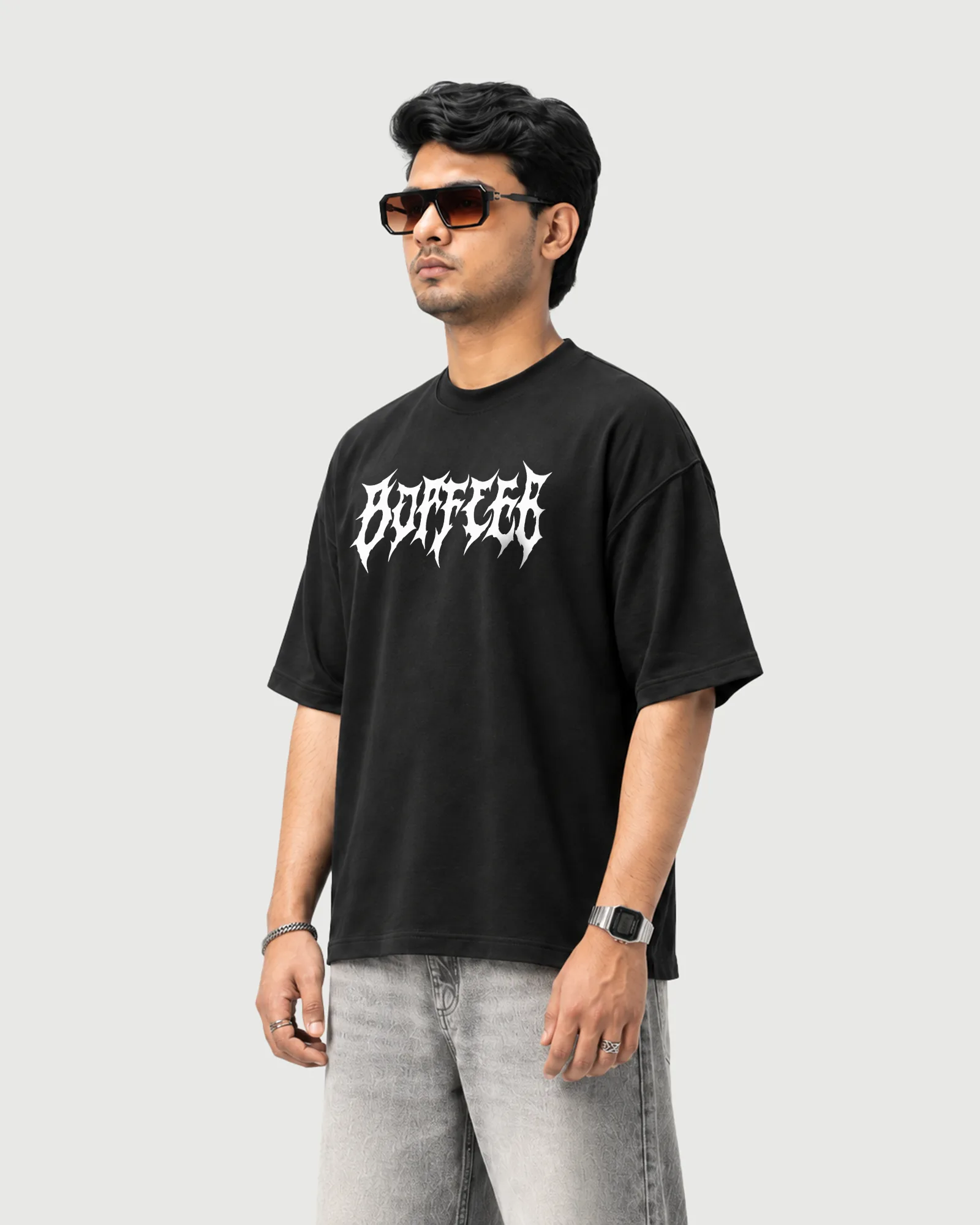 Three-quarter view of a model wearing the black Outflee Shadow Ronin drop shoulder T-shirt, showing the relaxed fit and gothic front lettering.