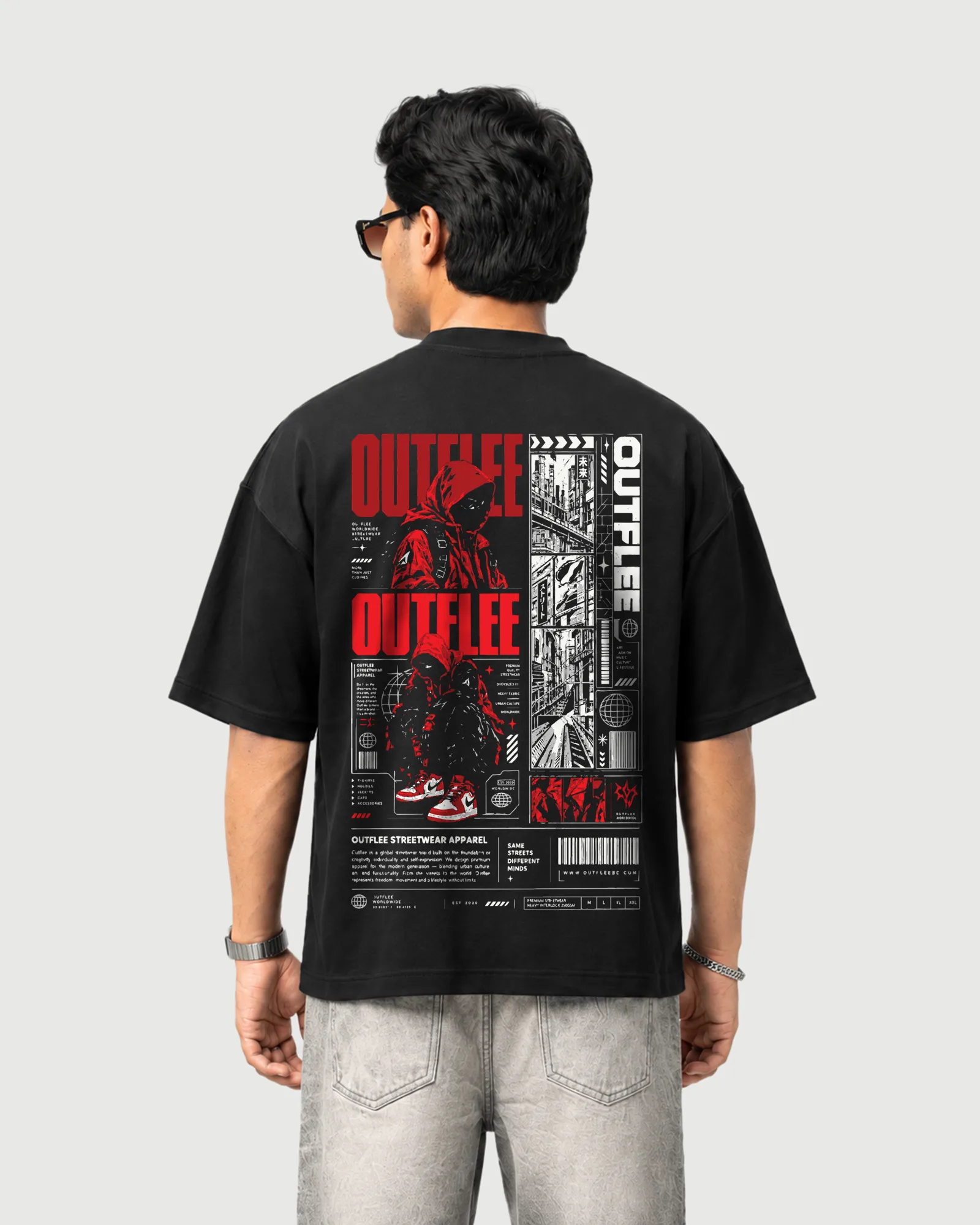 Model wearing the black Outflee Same Streets Different Minds drop shoulder T-shirt, back view showing hooded figures, urban street scenes and layered red, white and black graphics.