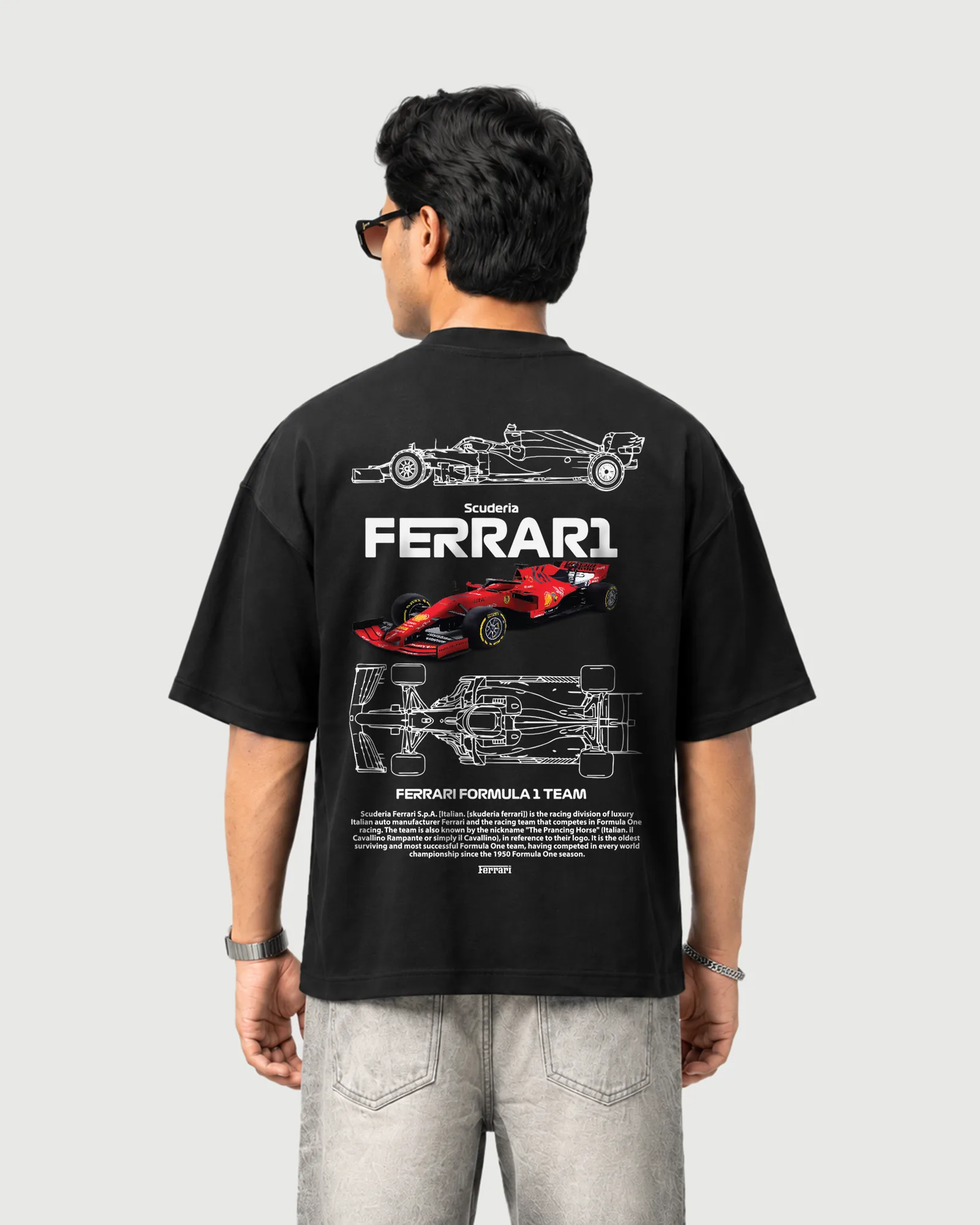 Model wearing the black Outflee Ferrari Formula 1 graphic drop shoulder T-shirt, back view showing the red Formula 1 race car, technical illustrations and Scuderia Ferrari graphics.