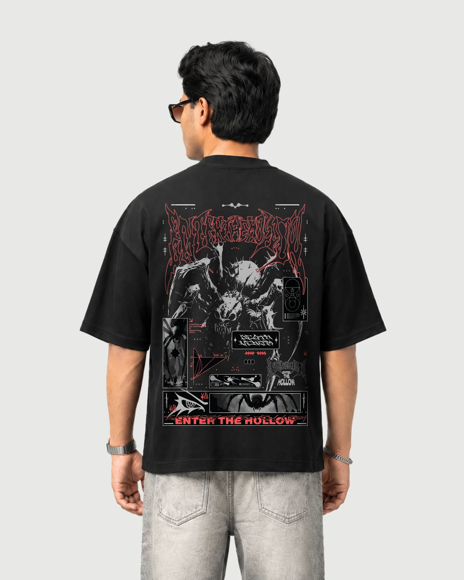 Model wearing the black Outflee Enter the Hollow drop shoulder T-shirt, back view showing the large dark creature artwork, red graphic details and Enter the Hollow typography.